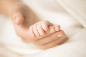 birth injury-mom holding baby's hand.