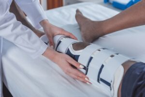 Personal Injury Claim-Doctor working on patient leg in brace